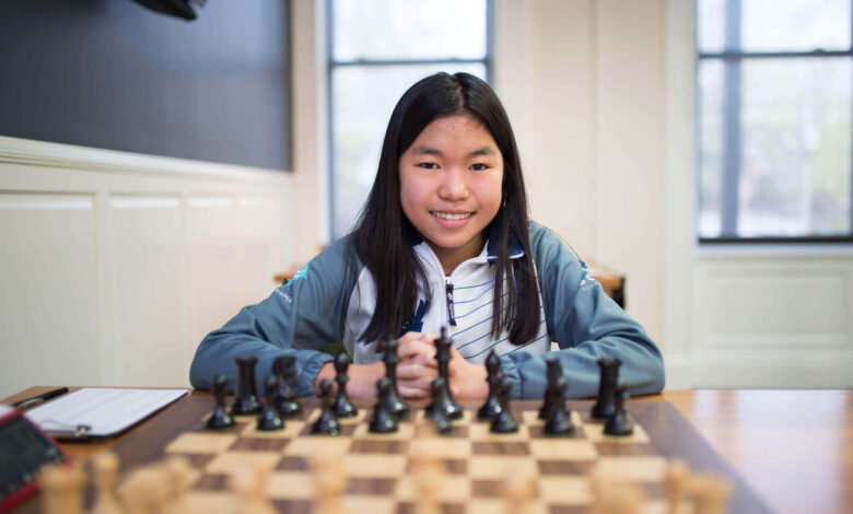 A Woman Sitting In Front of a Chess