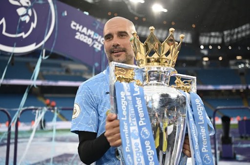 (Getty) Pep Guardiola holding his third Premier League title with Manchester City.
